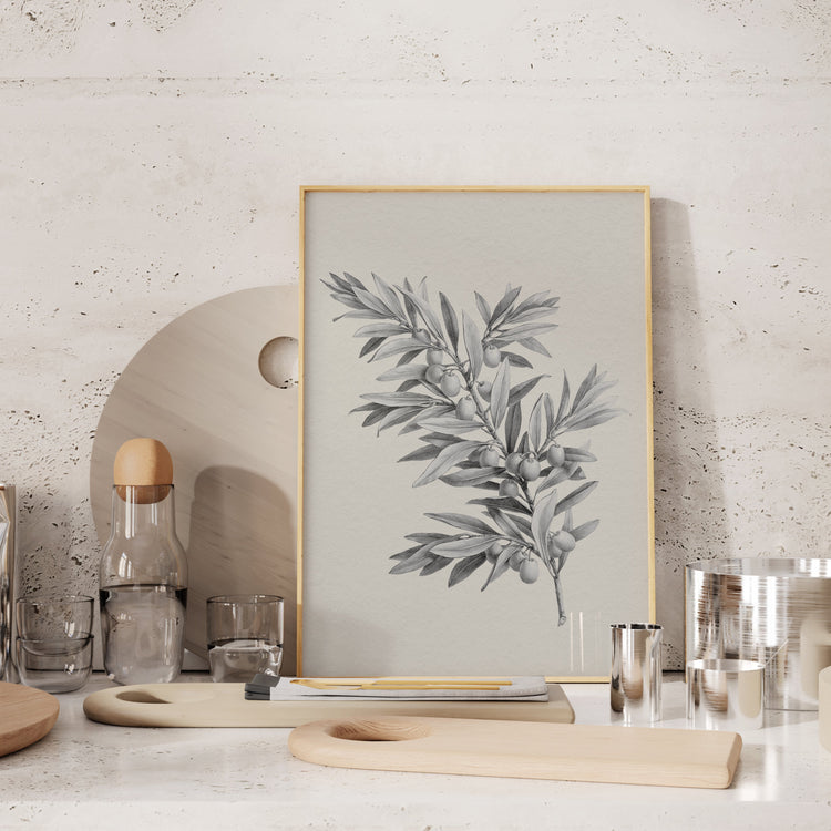 Framed vintage botanical strawberry print on a marble countertop in a kitchen.
