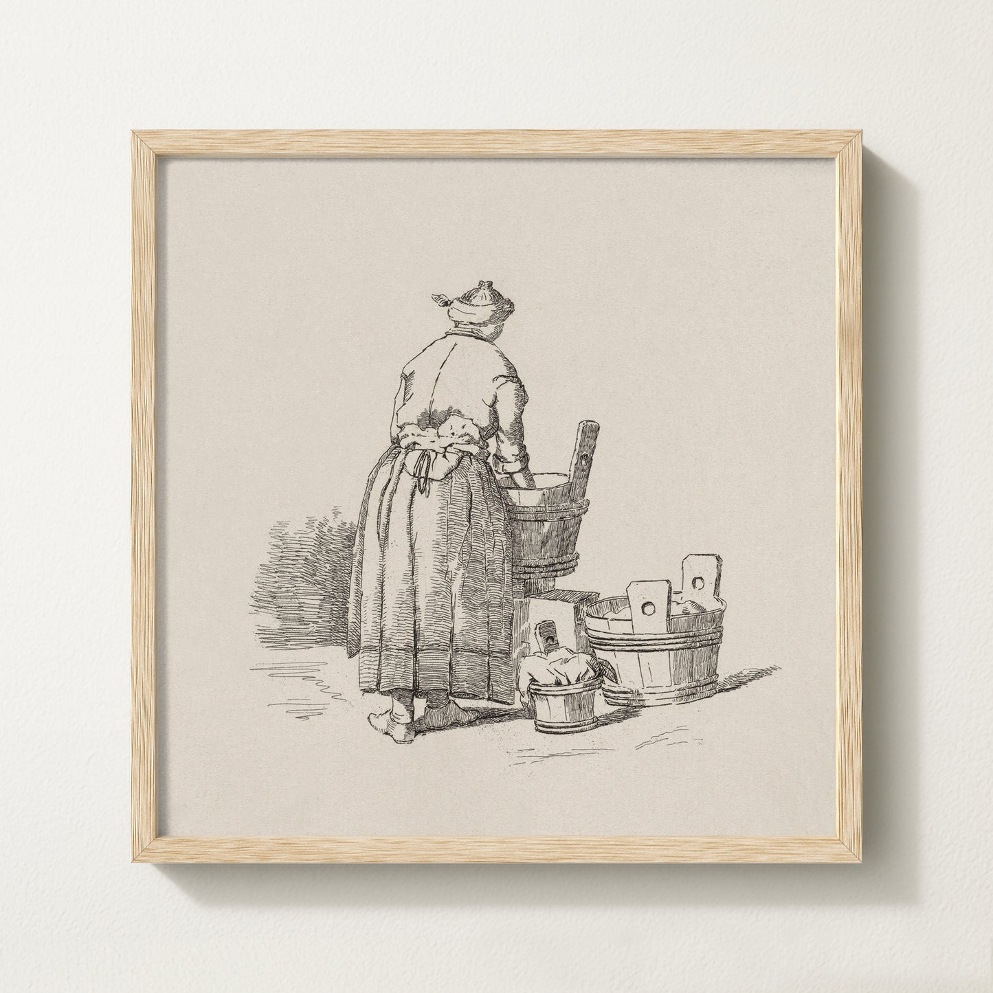 Framed vintage laundry sketch art print depicting a woman standing at wooden wash tubs in traditional attire.