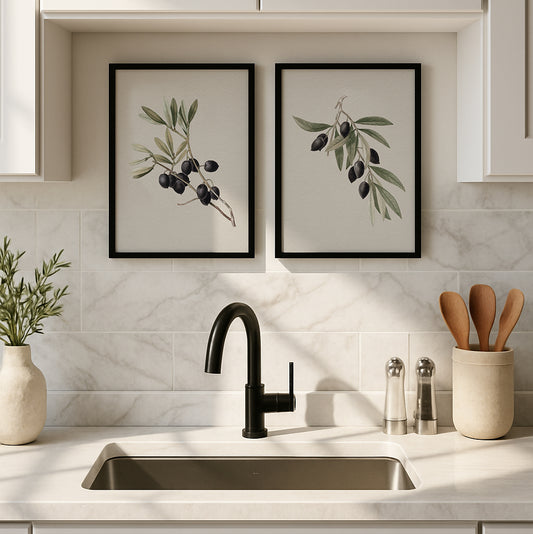 Pair of framed olive botanical art prints in black frames, styled above a modern kitchen sink with marble backsplash and neutral decor.