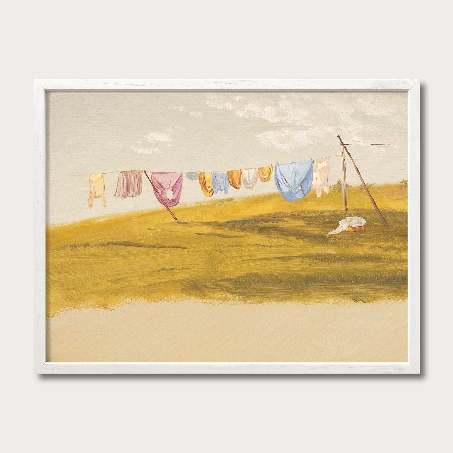 Vintage farmhouse laundry room wall art in a white wood frame featuring colorful laundry hanging on a clothesline in a peaceful countryside landscape for cottage, French country, and rustic homes.