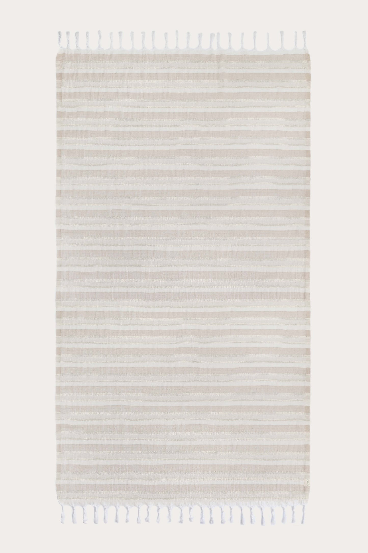 Avery Home Formentera beige and white herringbone peshtemal laid flat, full view of quick-dry Turkish cotton hammam towel with tassel fringe, for beach, spa, and bath