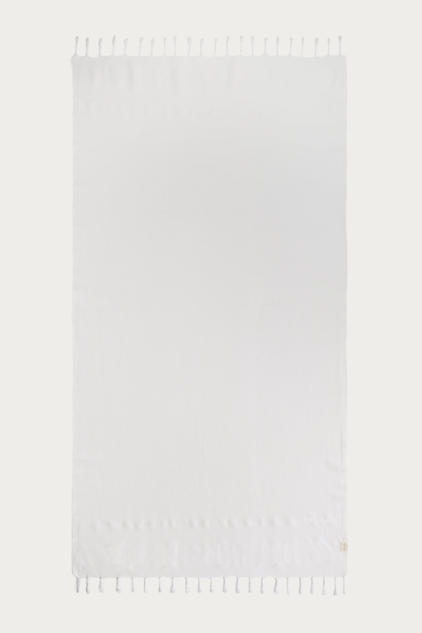 Avery Home white waffle weave peshtemal Turkish towel laid flat with hand-knotted tassel fringe – lightweight fast-drying luxurious spa towel