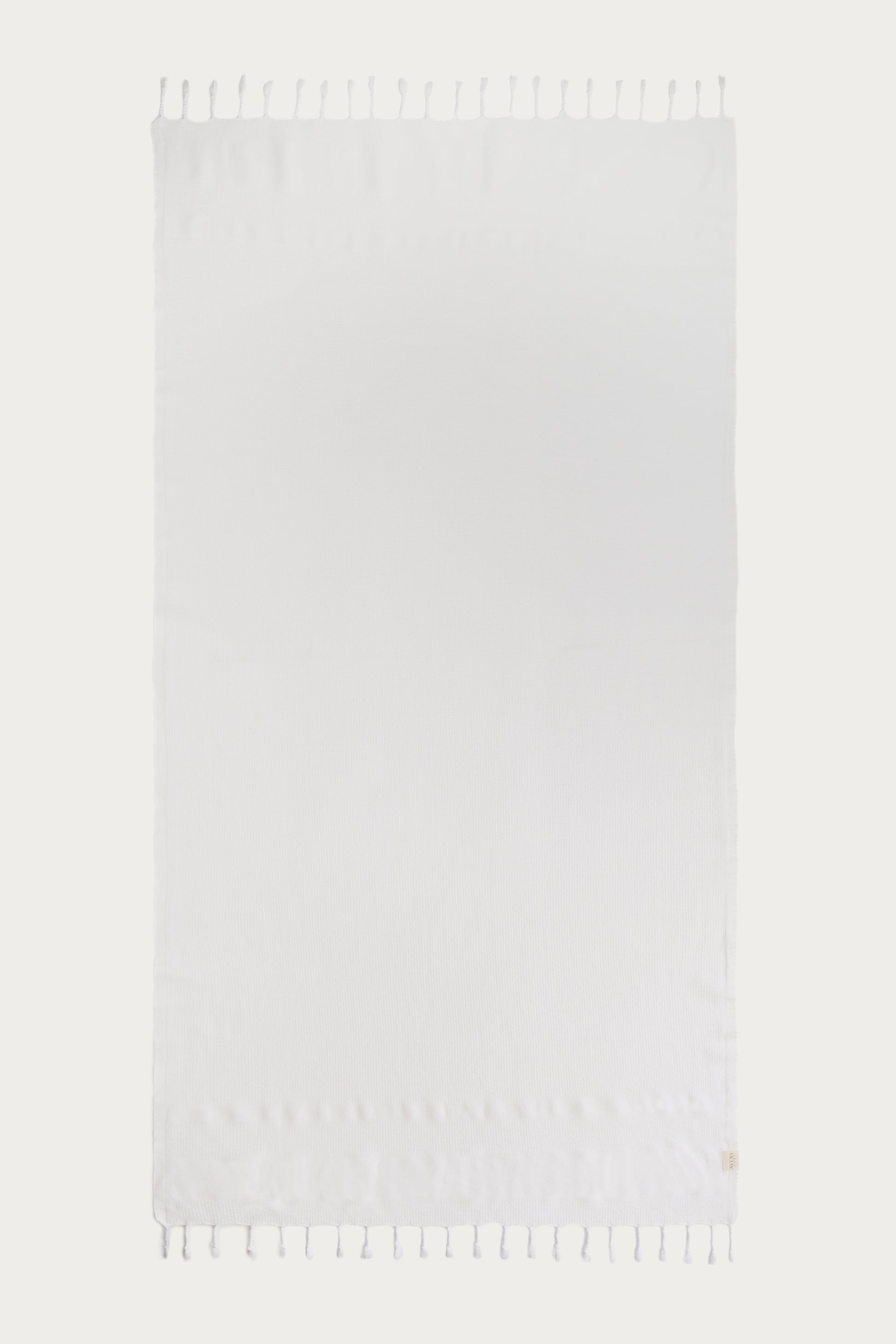 Avery Home white waffle weave peshtemal Turkish towel laid flat with hand-knotted tassel fringe – lightweight fast-drying luxurious spa towel
