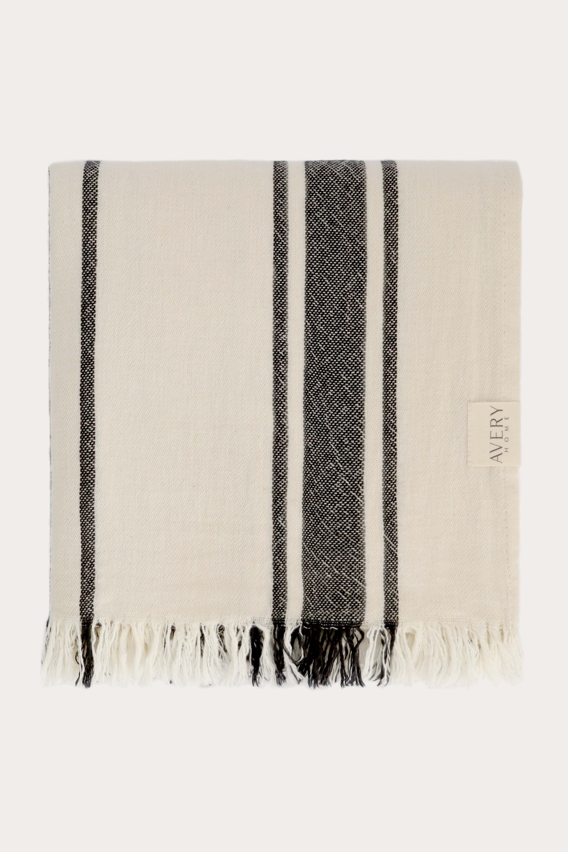Folded black and beige Amalfi Turkish towel in 100% motton with cabana stripe pattern and fringe edges, midweight flat weave by Avery Home
