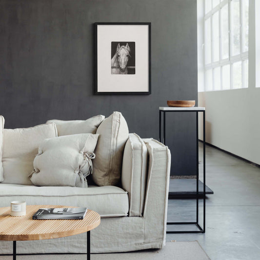Black framed horse sketch wall art displayed above a neutral modern minimalist living room sofa