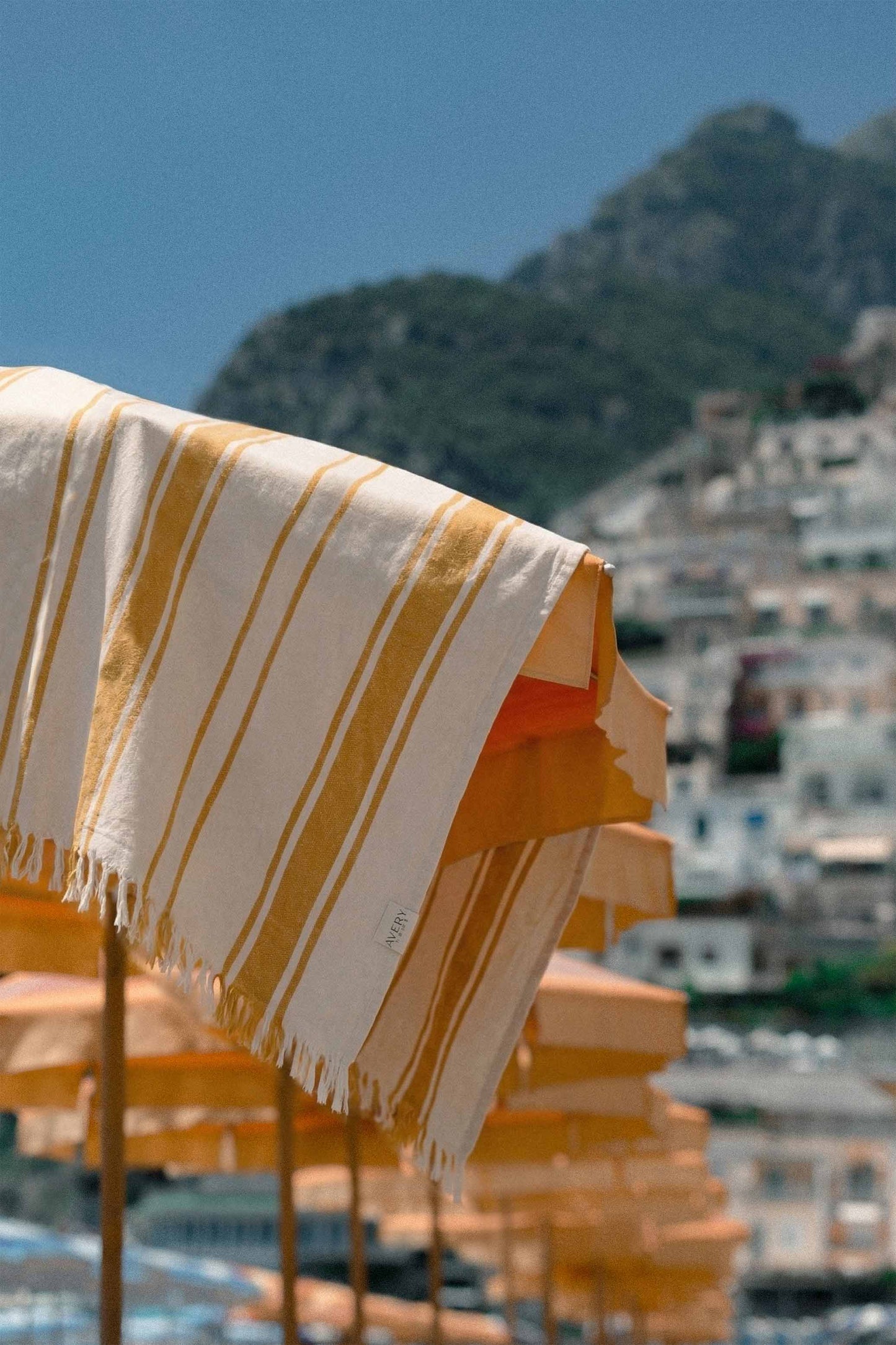 Yellow cabana striped Turkish beach towel draped over umbrella, lightweight cotton quick-dry towel for beach, pool, and travel
